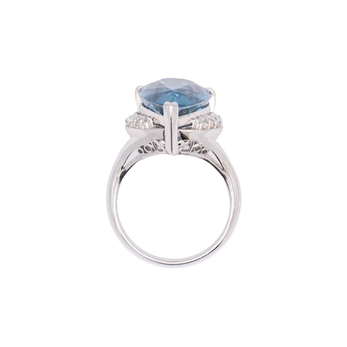 144 - A large Swiss blue topaz and diamond set dress ring in platinum. The pear-shaped mixed-cut topaz is ... 