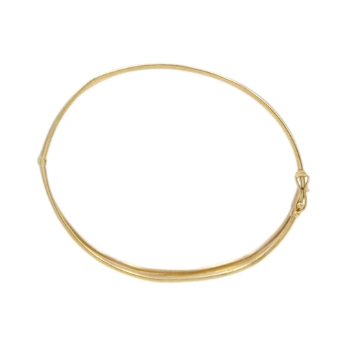 145 - A 9k oval hinged bangle with leaf-cut decoration. Stamped 375, width 64mm, 6.5g.