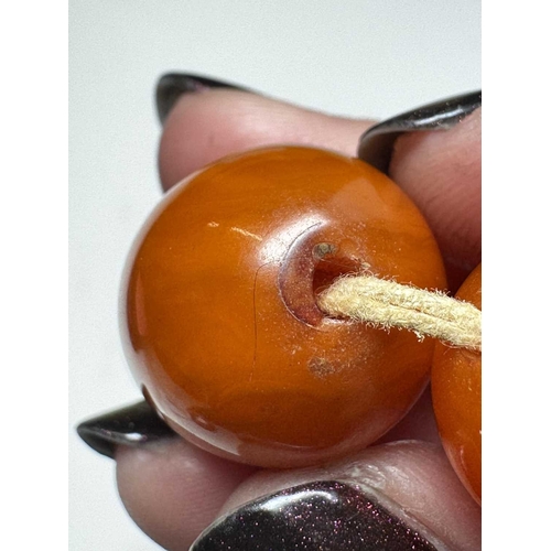 171 - A graduated butterscotch 'amber' style necklace. The oval beads are 8mm-23mm, forty-nine beads, scre... 