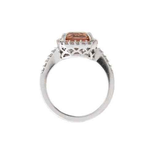 28 - A pinkish orange tourmaline and diamond set white gold ring. The square-shaped cushion-cut tourmalin... 