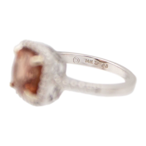 28 - A pinkish orange tourmaline and diamond set white gold ring. The square-shaped cushion-cut tourmalin... 