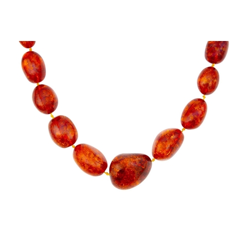 46 - A large graduated heat-treated cognac amber bead necklace with a pair of earrings. 'Sun spangles' in... 