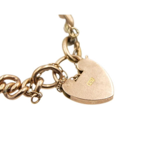 85 - A 9k rose gold curb link bracelet with a heart-shaped clasp. Fitted with a safety chain and a silver... 