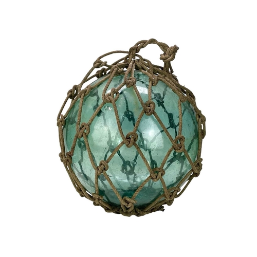 33 - Three large blown glass fishing floats. In varying green and blue tones, still with their original r... 