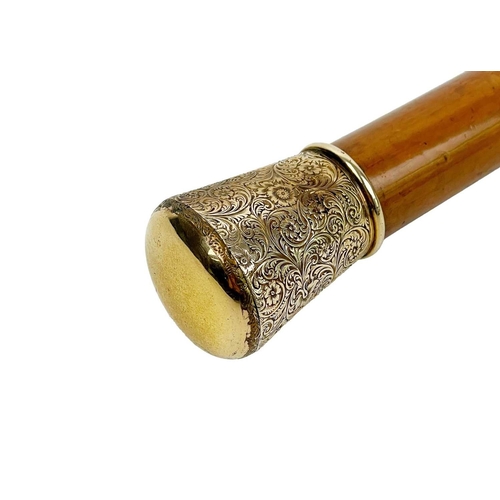 48a - A 19th century, gold topped, malacca walking cane. The finial with foliate scroll embossed decoratio... 