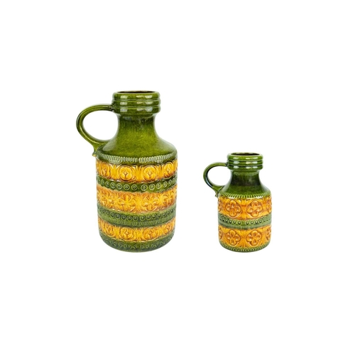715 - A graduated pair of West German vases. Green and ochre glaze, each with a side handle and impressed ... 