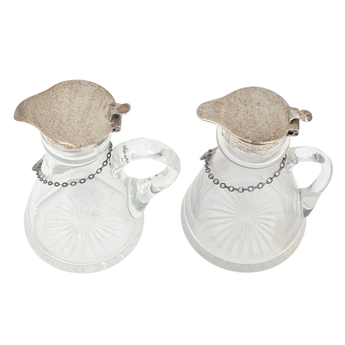 192 - Two silver mounted cut glass whisky noggins. The hinged covers marked for Chester, 1911, and London,... 
