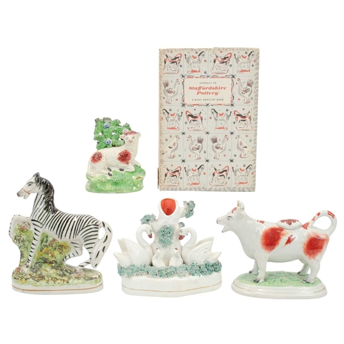 278 - Four Staffordshire pottery animal figures. Includes a Zebra, height 16cm, a swan family spill vase, ... 