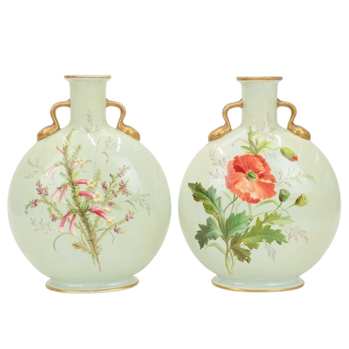 300 - A pair of porcelain moon flasks. Circa 1880, probably Minton, each with gilt handles and floral pain... 