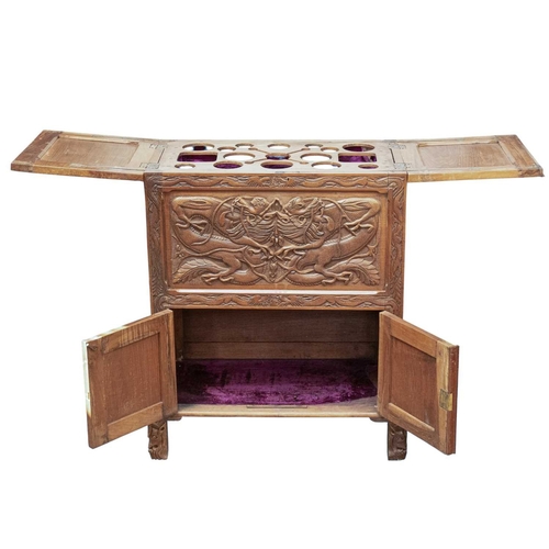 369 - A Chinese carved teak drinks or cocktail cabinet. Mid 20th century, with twin hinged compartments op... 