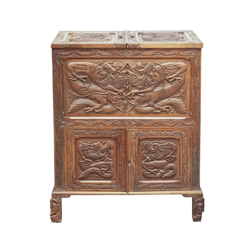 369 - A Chinese carved teak drinks or cocktail cabinet. Mid 20th century, with twin hinged compartments op... 
