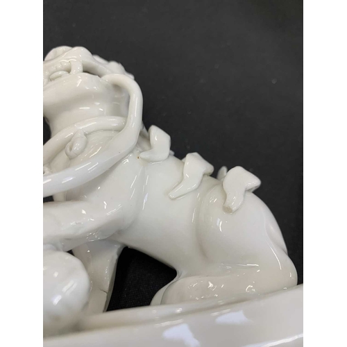 372 - A pair of Chinese blanc de chine Buddhistic lions. Qianlong, each beast rests its paw upon a ball, o... 