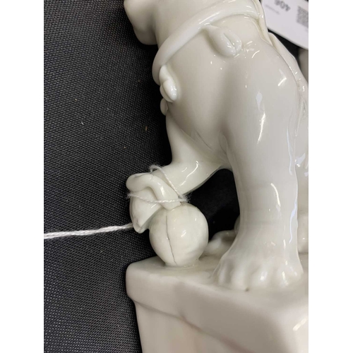 372 - A pair of Chinese blanc de chine Buddhistic lions. Qianlong, each beast rests its paw upon a ball, o... 