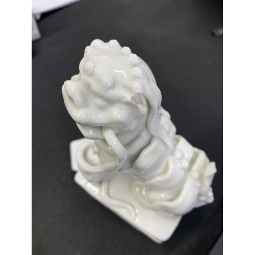 372 - A pair of Chinese blanc de chine Buddhistic lions. Qianlong, each beast rests its paw upon a ball, o... 