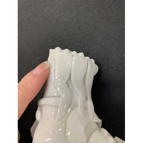 372 - A pair of Chinese blanc de chine Buddhistic lions. Qianlong, each beast rests its paw upon a ball, o... 