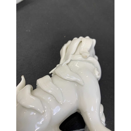 372 - A pair of Chinese blanc de chine Buddhistic lions. Qianlong, each beast rests its paw upon a ball, o... 