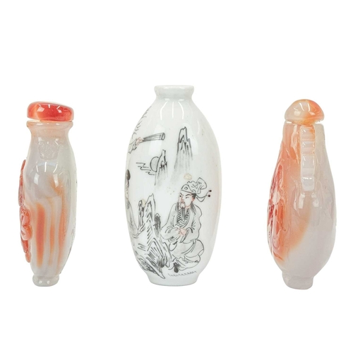 394 - Three Chinese snuff bottles. 19th/20th century, an ovoid porcelain example, painted with figures in ... 