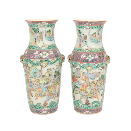 397 - A pair of Cantonese famille rose vases. Late 19th century, decorated with reserves of fighting figur... 