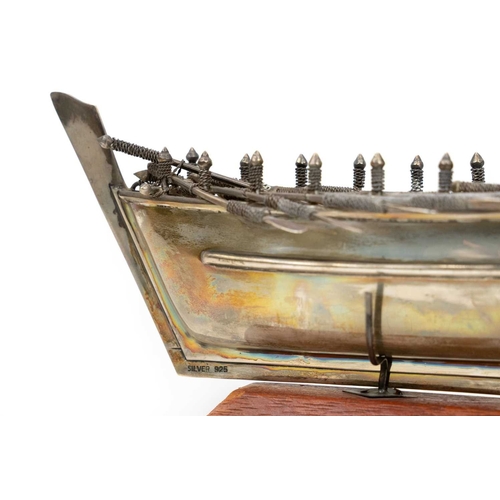 413 - A Middle Eastern silver model of a rowing boat. With eight pairs of oars and a tiller, length 20.5cm... 