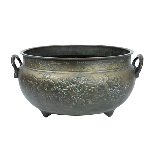 415 - A large Chinese bronze tripod censer, ding. Qing dynasty, with twin handles, cast in relief and chas... 