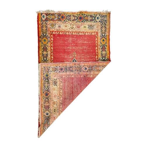 478 - An antique Ushak rug. Late 19th century, the red field with one central medallion, within a navy and... 