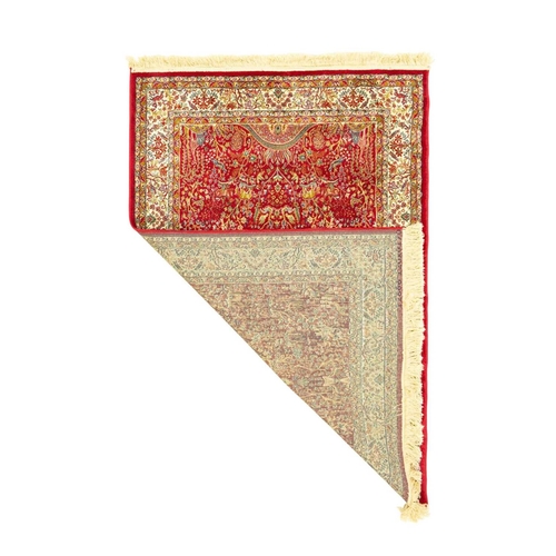 482 - A cashmere 'Tree of Life' rug. Modern, red ground, the central panel depicting giraffes and other an... 