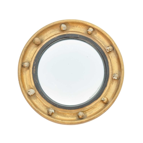 520 - A 19th century giltwood convex mirror. With circular plate and reeded ebonised slip. Diameter 29cm. ... 