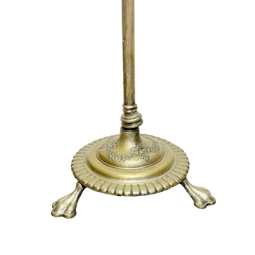 524 - A Victorian brass standard oil lamp. Raised on a circular cast base with three lion's paw feet, with... 