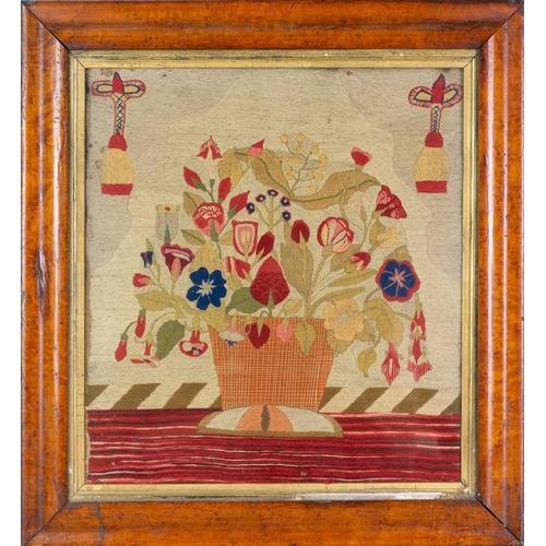 561 - A Regency needlepoint embroidered picture. Worked with a basket of flowers, 41 x 37cm, in a maple fr... 