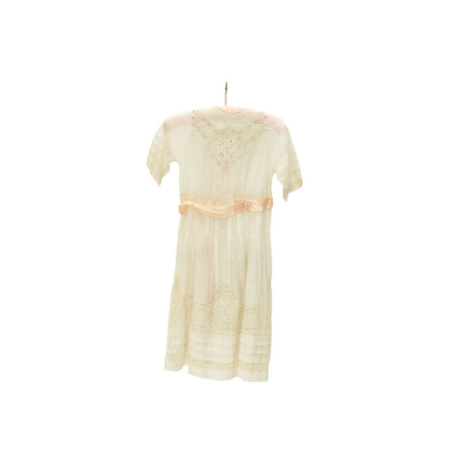 566 - A girl's dress, circa 1900. White muslin with whitework embroidery and lace panels, mother of pearl ... 