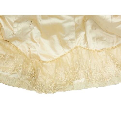 569 - A late Victorian ivory silk two-piece wedding dress. The boned bodice with lace overlay and sleeves,... 