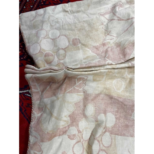 570 - A pair of linen curtains. Patterned with fruiting vine leaves in pink and beige, pleat top with cott... 