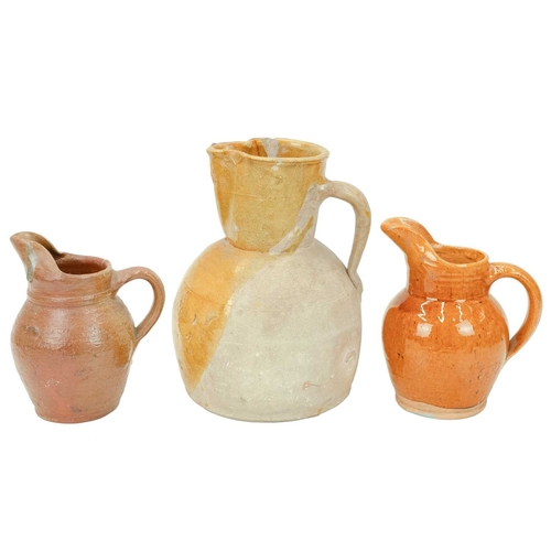 593 - A French mustard glaze terracotta jug. Circa 1900, with a pinched spout and loop handle, height 25cm... 