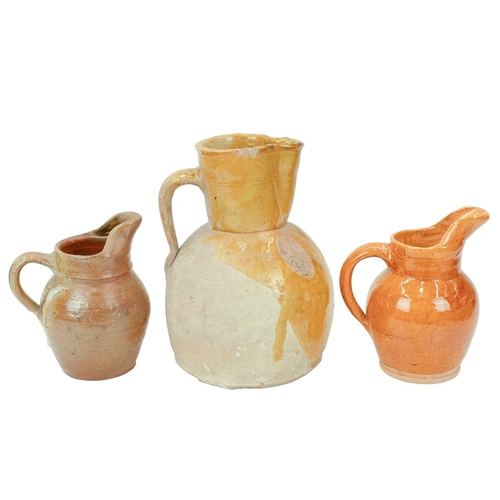 593 - A French mustard glaze terracotta jug. Circa 1900, with a pinched spout and loop handle, height 25cm... 