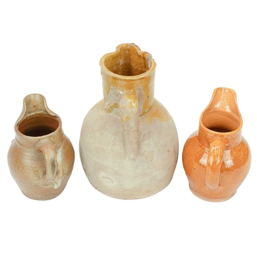 593 - A French mustard glaze terracotta jug. Circa 1900, with a pinched spout and loop handle, height 25cm... 