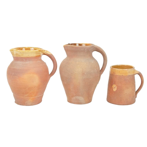 599 - Lakes Cornish pottery, Truro. Three terracotta jugs, the largest 20.5cm, all marked, together with a... 