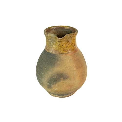 604 - A Verwood (Dorset) pottery jug. Late 19th century, with part glazed body, height 21cm.