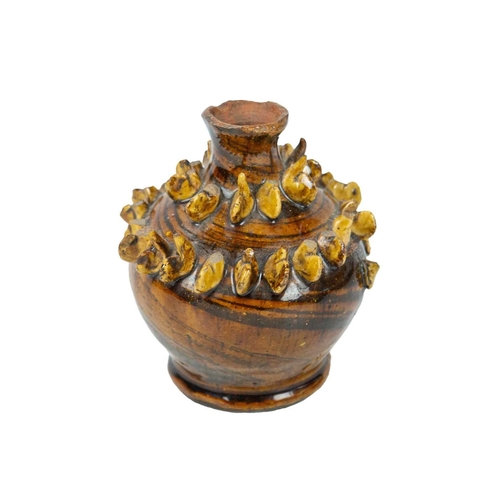614 - A treacle glazed agateware money box. Possibly Yorkshire, 19th century, of baluster shape, applied w... 