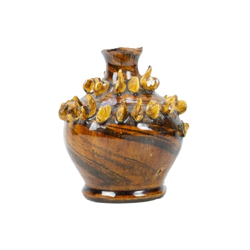 614 - A treacle glazed agateware money box. Possibly Yorkshire, 19th century, of baluster shape, applied w... 