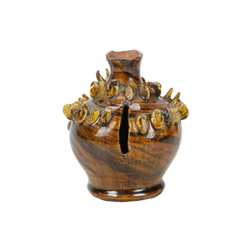 614 - A treacle glazed agateware money box. Possibly Yorkshire, 19th century, of baluster shape, applied w... 