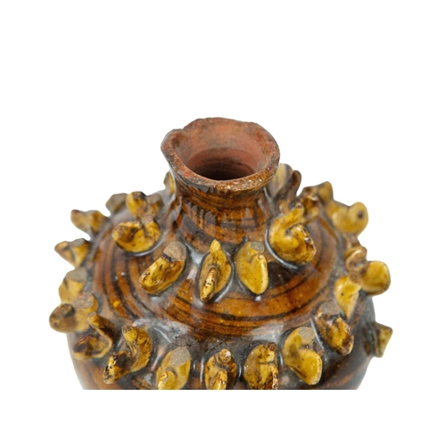 614 - A treacle glazed agateware money box. Possibly Yorkshire, 19th century, of baluster shape, applied w... 