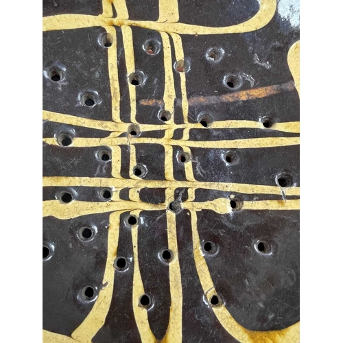 622 - An English slipware pottery colander or strainer dish. Late 18th century, the chocolate ground with ... 