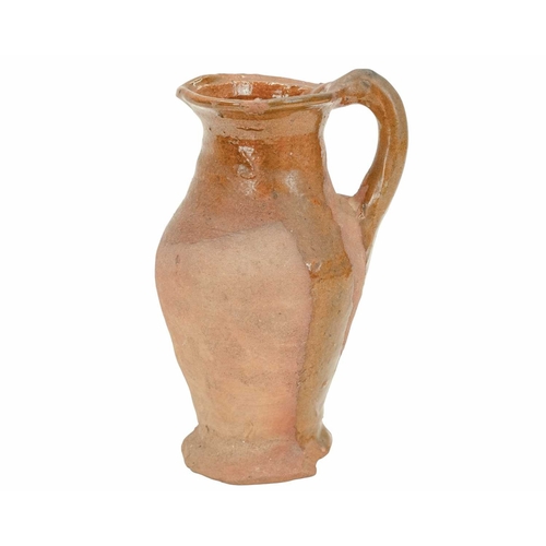 640 - An English post-medieval redware earthenware jug. The clear glazed interior extends to the handle an... 