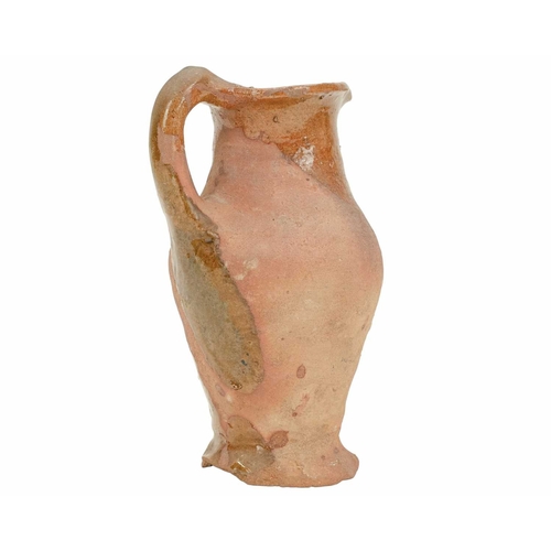 640 - An English post-medieval redware earthenware jug. The clear glazed interior extends to the handle an... 