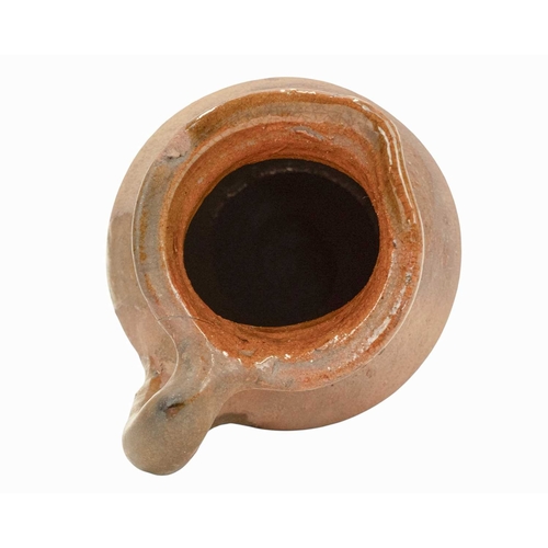 640 - An English post-medieval redware earthenware jug. The clear glazed interior extends to the handle an... 
