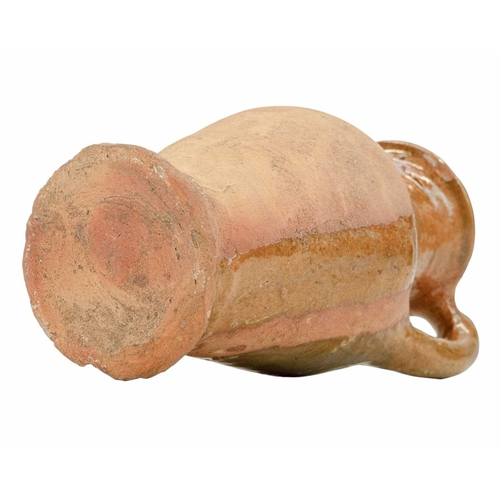 640 - An English post-medieval redware earthenware jug. The clear glazed interior extends to the handle an... 