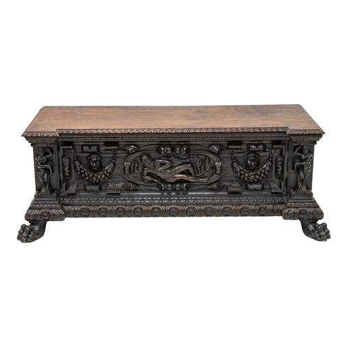651 - An Italian walnut cassone. 18th century, the hinged lid with a gadrooned edge, the well carved front... 