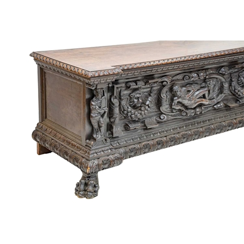 651 - An Italian walnut cassone. 18th century, the hinged lid with a gadrooned edge, the well carved front... 