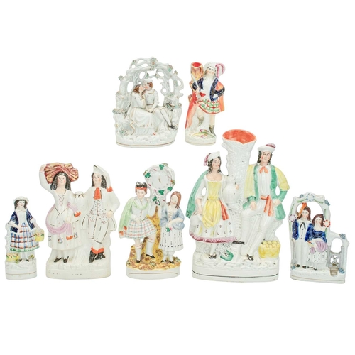 653 - Seven Victorian Staffordshire figures and groups. Including a porcelanous group of lovers under an a... 