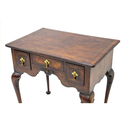 654 - A George II style walnut lowboy. The herringbone banded top with re-entrant corners above a small ce... 